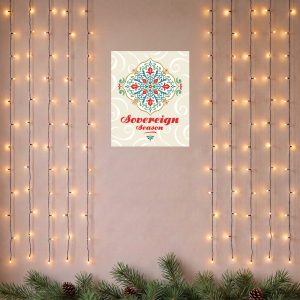 Sovereign Season Holiday Poster hanging on wall, surrounded by string lights and pine branches along the bottom edge.